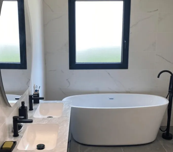 Salle de bain avec baignoire îlot et carrelage effet marbre